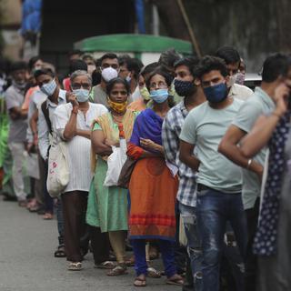 Des personnes attendent pour recevoir un vaccin contre le Covid-19 à Mumbai en Inde. [AP Photo - Rafiq Maqbool]