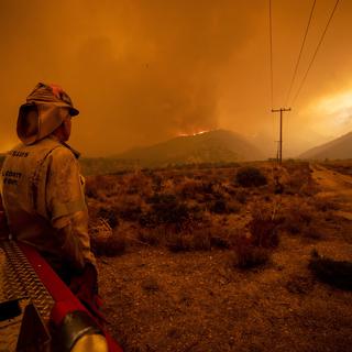 Un pompier observe les feux en Californie [KEYSTONE - EPA/ETIENNE LAURENT]