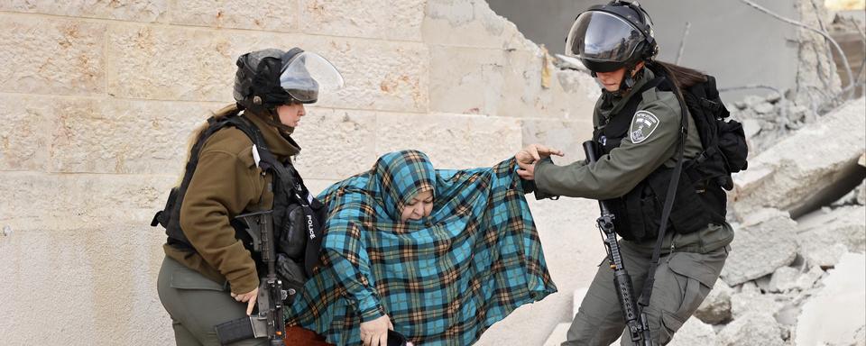 Mardi 28 décembre: des soldates israéliennes tentent d'entraîner une Palestinienne qui s'oppose à la destruction de sa maison, dans la ville de Hebron en Cisjordanie. [AFP - Hazem Bader]