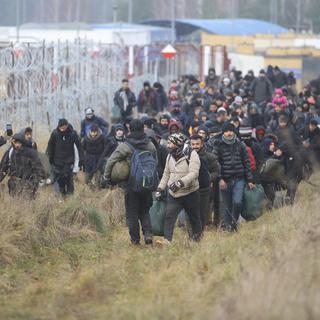 Des migrants et migrantes à la frontière entre la Biélorussie et la Pologne. [BelTA pool photo via AP - Leonid Shcheglov]