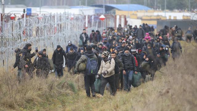 Des migrants et migrantes à la frontière entre la Biélorussie et la Pologne. [BelTA pool photo via AP - Leonid Shcheglov]