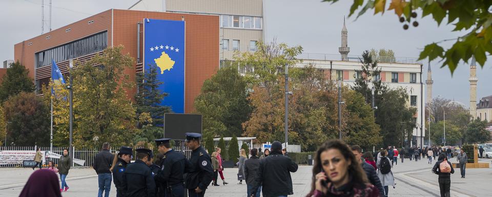 Des personnes marchent dans une rue piétonne de Pristina au Kosovo. Photo prise en 2019. [Keystone - Jean-Christophe Bott]