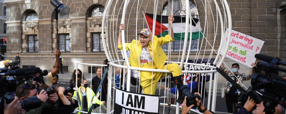 La styliste Vivienne Westwood posait dans une cage pour protester contre l'extradition du fondateur de Wikleaks, Julien Assange, à la Cour pénale centrale communément appelée "The Old Bailey" à Londres, en Grande-Bretagne, le 21 juillet 2020. [EPA - Neil Hal]