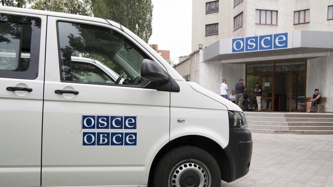 Un bus de l'OSCE photographié devant un bâtiment de l'OSCE en Urkaine. [Keystone - Anthony Anex]