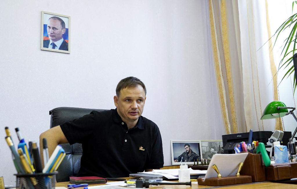 Kirill Stremousov, ancien influenceur bien-être "mystique" et adepte de théories du complot, nouveau chef adjoint de l'administration pro-russe de Kherson, est photographié dans son bureau, avec un portrait du président russe Vladimir Poutine sur le mur derrière lui, dans la ville de Kherson, le 20 juillet 2022. [AFP - STRINGER]