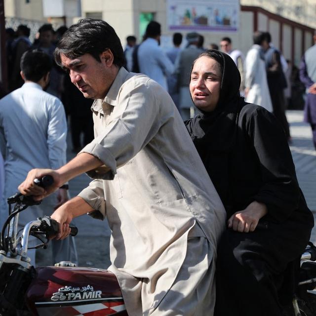 Une femme et un homme arrivent à moto dans un hôpital de Kaboul à la recherche d'une victime de l'attentat qui a fait une trentaine de morts. [AFP]