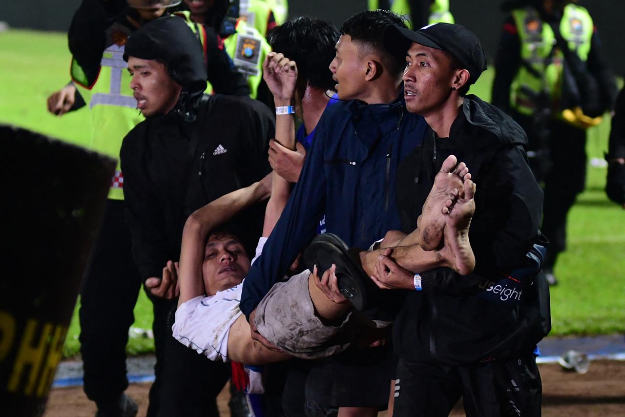 Un groupe de supporters s'occupe d'un homme blessé. [AFP - STR]