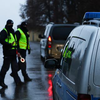 Deux policiers polonais près du lieu de l'impact du tir de missile dans le village de Przewodow. [Reuters - Kacper Pempel]