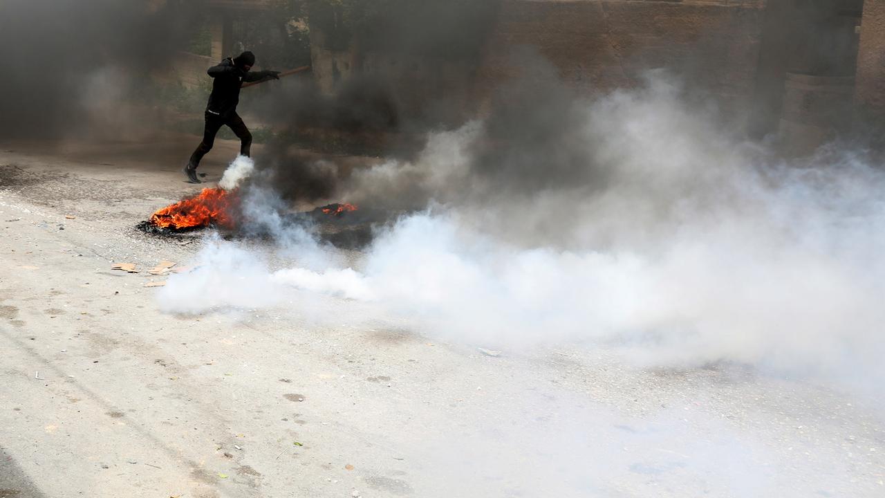 Un Palestinien repousse une grenade lacrymogène lors d'affrontements avec des soldats israéliens dans le village de Burqa, près de la ville de Naplouse, en Cisjordanie, le 19 avril 2022 [EPA - ALAA BADARNEH]