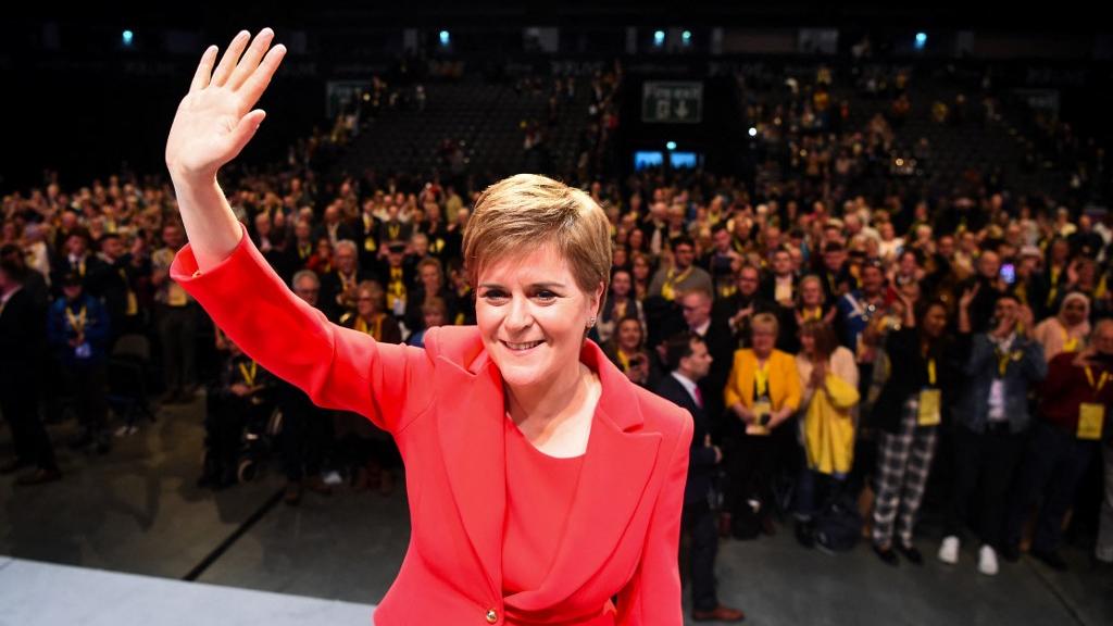 La Première ministre écossaise et leader du Scottish National Party (SNP), Nicola Sturgeon, salue les membres du public alors qu'elle quitte la scène après avoir prononcé son discours devant les délégués lors de la conférence annuelle du SNP à Aberdeen, en Écosse, le 10 octobre 2022. [AFP - ANDY BUCHANAN]