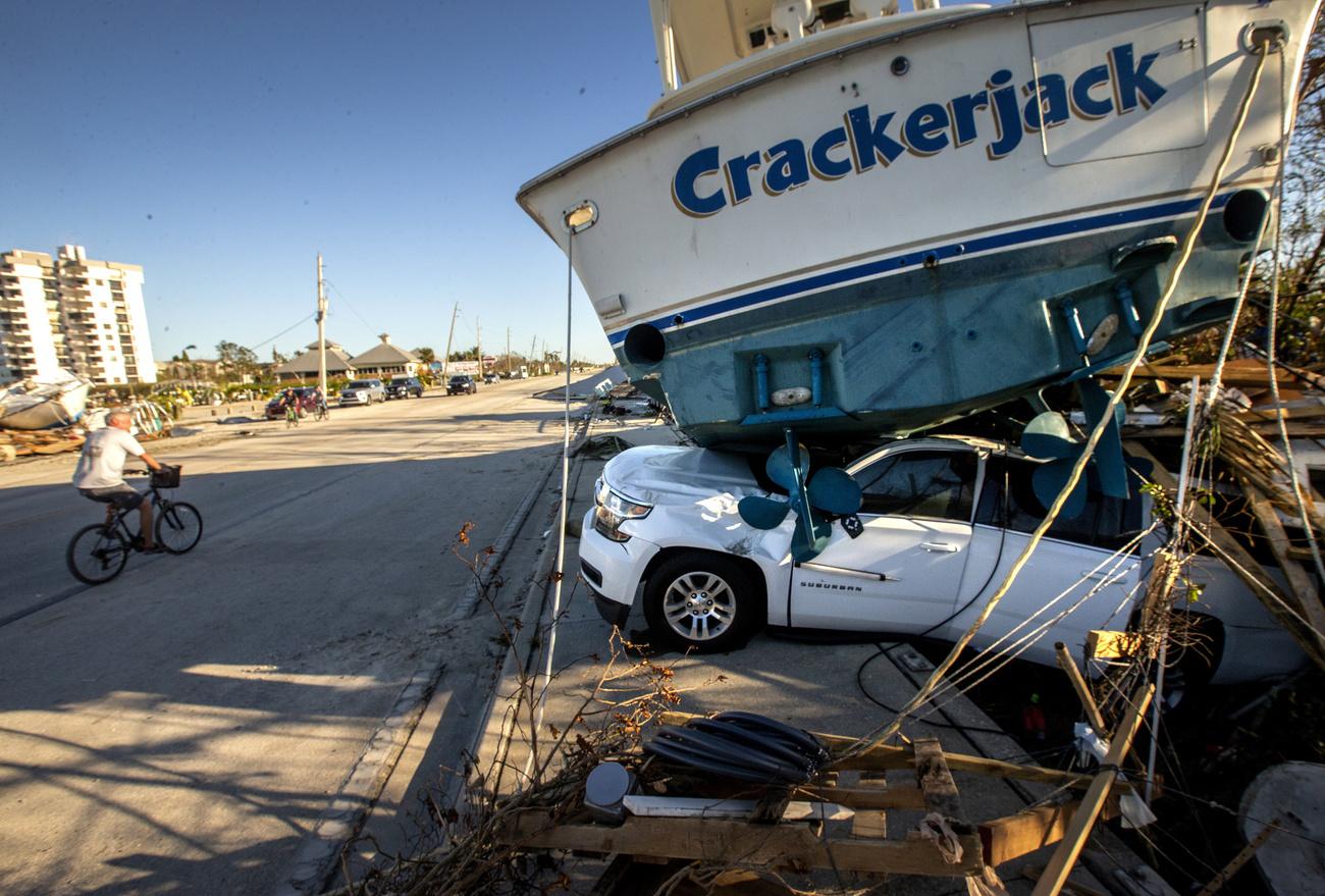 Un bateau se trouve sur le toit d'une voiture sur l'île de San Carlos après le passage de l'ouragan Ian, à Fort Myers Beach, Floride, États-Unis, le 30 septembre 2022. [KEYSTONE - CRISTOBAL HERRERA-ULASHKEVICH]