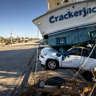 Un bateau se trouve sur le toit d'une voiture sur l'île de San Carlos après le passage de l'ouragan Ian, à Fort Myers Beach, Floride, États-Unis, le 30 septembre 2022. [KEYSTONE - CRISTOBAL HERRERA-ULASHKEVICH]
