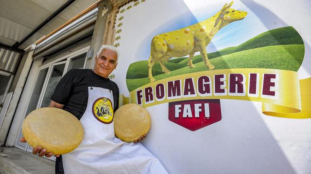 Rachid Ibersiene, 57 ans, prend la pose devant sa fromagerie au pied du mont Tamgout, en l'Algérie, le 12 juin 2023. [AFP]