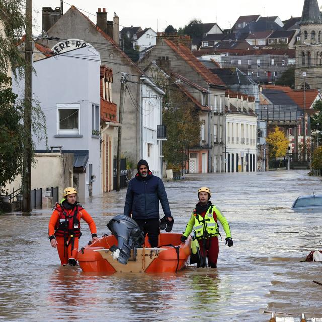 Des pompiers aident un habitant à évacuer dans une rue inondée de Isques, près de Boulogne-sur-Mer, dans le nord de la France, le 7 novembre. [AFP - Denis Charlet]