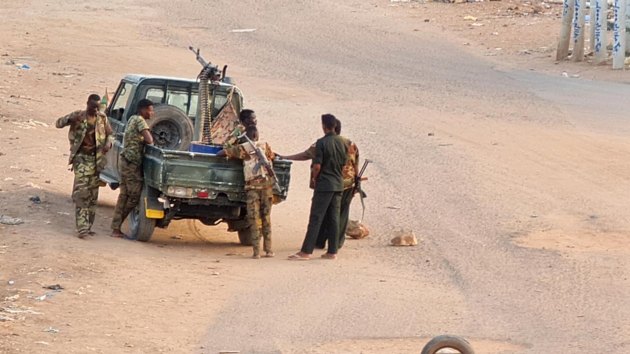 Des soldats de l'armée soudanaise se tiennent près de leur véhicule sur une route bloquée par des briques à Khartoum le 20 mai 2023, alors que les violences entre deux généraux rivaux se poursuivent. [AFP]