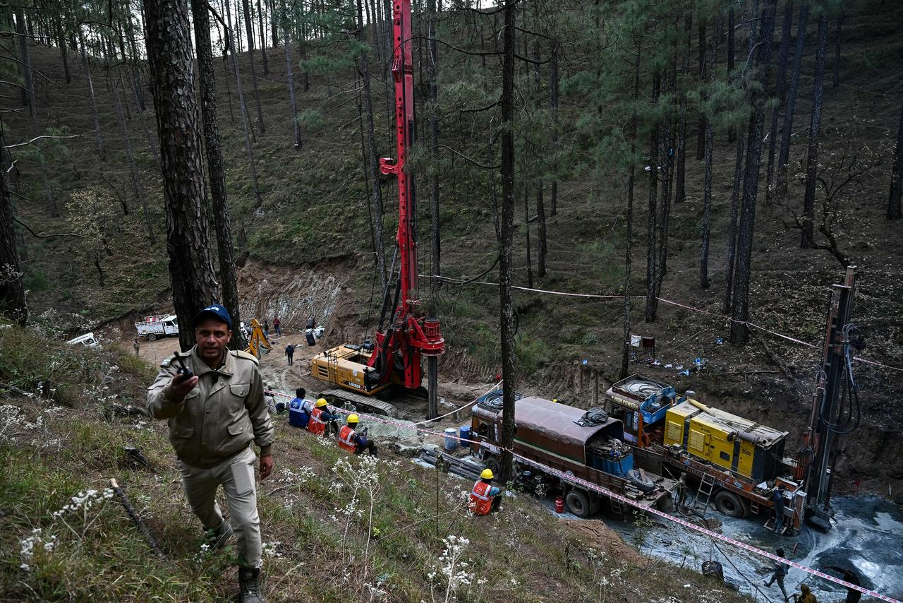 Un forage vertical avait été entamé samedi pour tenter d'atteindre le tunnel, environ 89 mètres plus bas, dans une opération d'excavation complexe. [AFP - Arun Sankar]