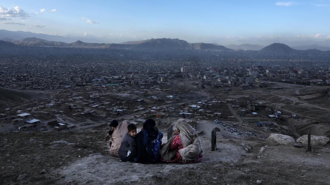 Une famille pleure sur la tombe de leur fille morte dans l'attaque d'une école à Kaboul le 11 mai 2021. Quelque 80 personnes avaient perdu la vie dans cet attentat terroriste. [KEYSTONE - EPA/HEDAYATULLAH AMID]