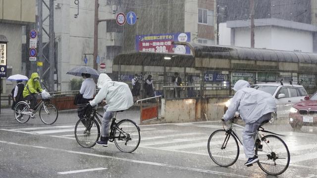 Des personnes se déplacent sous une forte pluie à Kochi, dans le sud du Japon, le 2 juin 2023. La tempête tropicale Mawar a apporté de fortes pluies sur les principales îles du sud du Japon vendredi, après avoir traversé l'archipel d'Okinawa et causé des blessures à plusieurs personnes. [Kyodo News via AP]