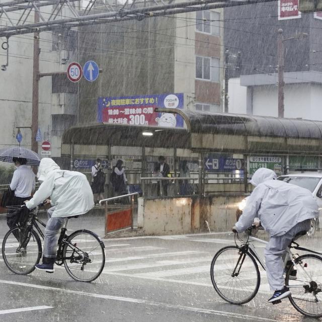 Des personnes se déplacent sous une forte pluie à Kochi, dans le sud du Japon, le 2 juin 2023. La tempête tropicale Mawar a apporté de fortes pluies sur les principales îles du sud du Japon vendredi, après avoir traversé l'archipel d'Okinawa et causé des blessures à plusieurs personnes. [Kyodo News via AP]