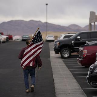 Un homme avec un drapeau des Etats-Unis. (Image d'illustration) [AP Photo - John Locher]
