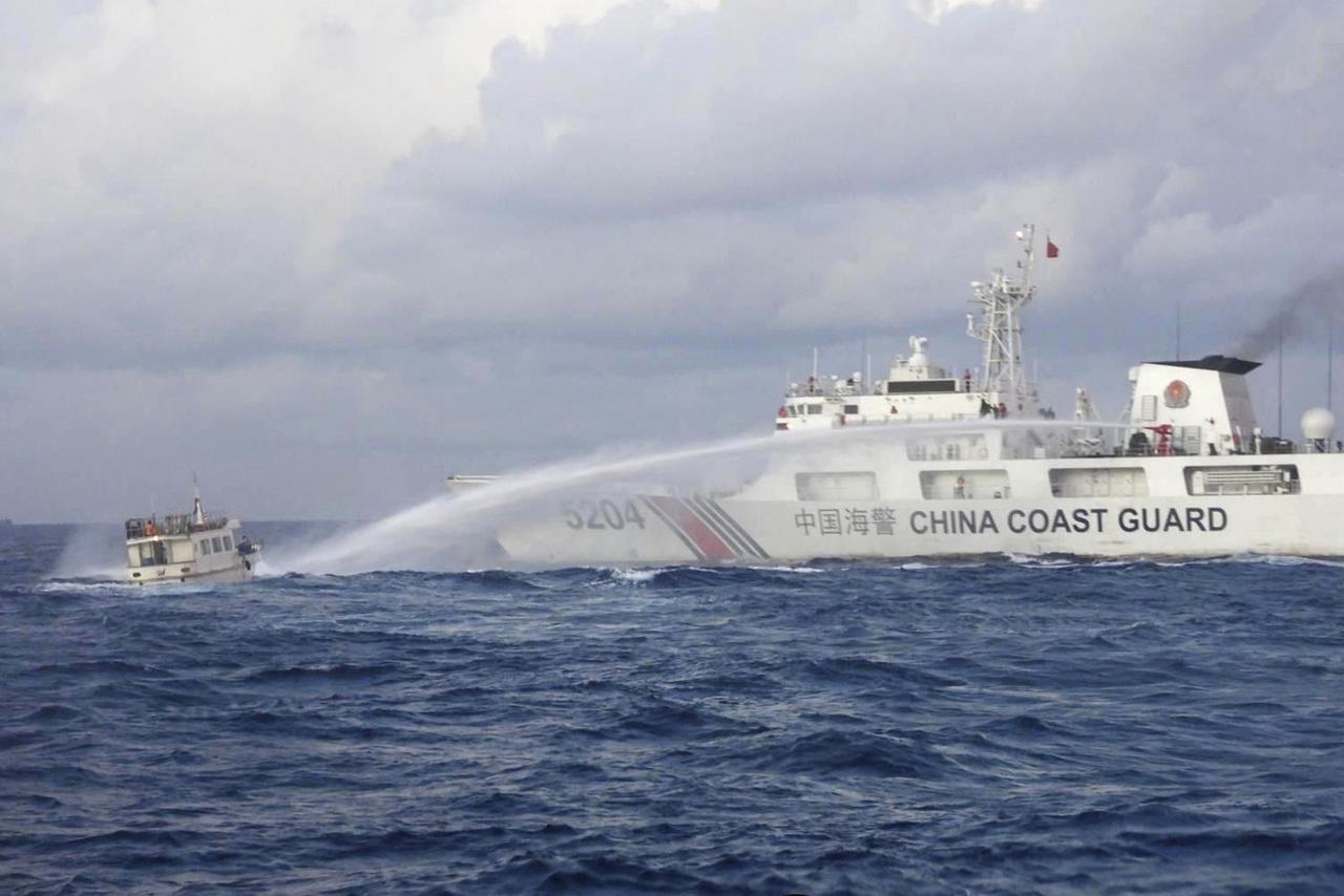 Sur cette photo fournie par les garde-côtes philippins, un navire des garde-côtes chinois utilise des canons à eau sur le bateau de ravitaillement M/L Kalayaan de la marine philippine alors qu'il s'approche du Second Thomas Shoal, connu localement sous le nom de Ayungin Shoal, dans la mer de Chine méridionale contestée, le dimanche 10 décembre 2023. [AP Photo - Philippine Coast Guard]