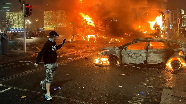 Plusieurs véhicules, dont une voiture de police et un bus ont été incendiés à Dublin en réaction à une attaque au couteau qui a fait cinq blessés. [AFP - Peter Murphy]