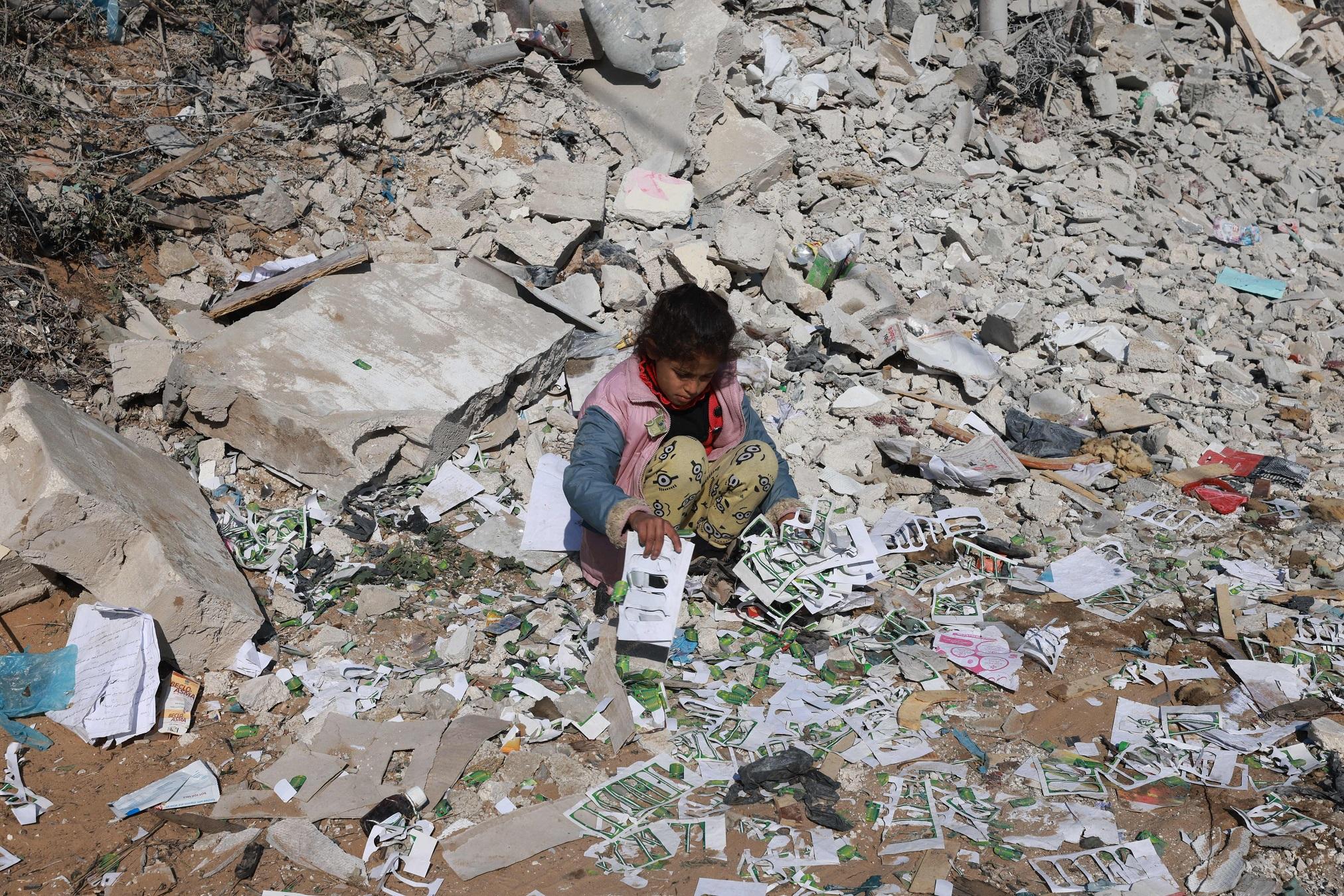 Une jeune fille fouille parmi les débris à Khan Younès, dans la bande de Gaza, le 16 janvier 2024. [AFP]