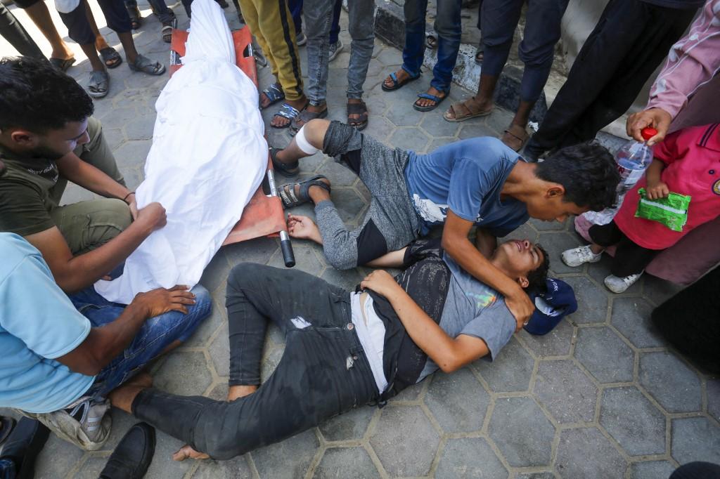 Les proches de Palestiniens décédés se recueillent autour d'un corps amené à la morgue à Deir Al Balah, dans la bande de Gaza, le 12 juin 2024 [AFP - ASHRAF AMRA]