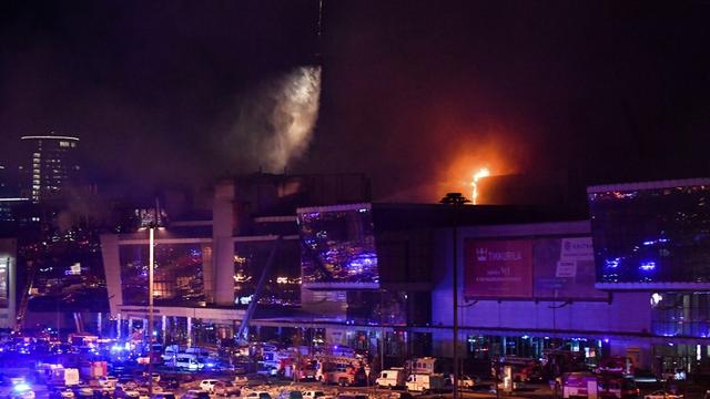 Un hélicoptère largue de l'eau sur la salle de concert Crocus City Hall en flammes, dans la banlieue de Moscou. [AFP - OLGA MALTSEVA]