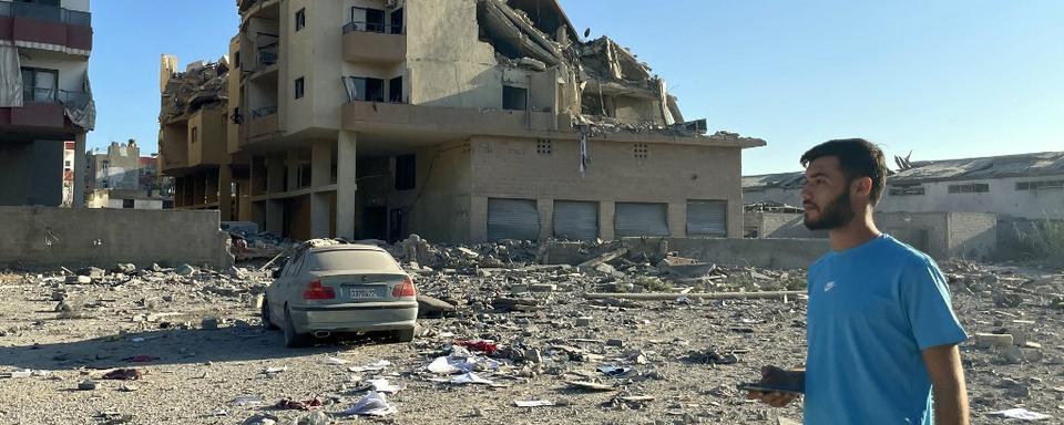 Un homme passe devant les destructions causées par les frappes aériennes israéliennes à la périphérie de Tyr, le 26 septembre 2024. [AFP - Hassan FNEICH]