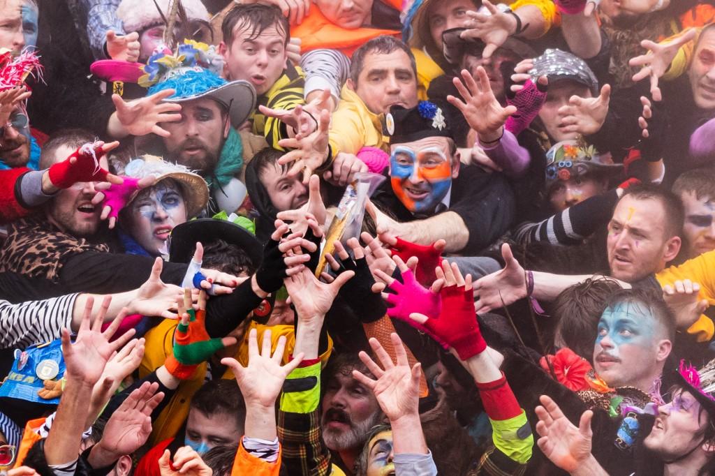 Des fêtards tentent d'attraper des harengs lors du carnaval de Dunkerque, le 11 février 2024. [AFP - SAMEER AL-DOUMY]