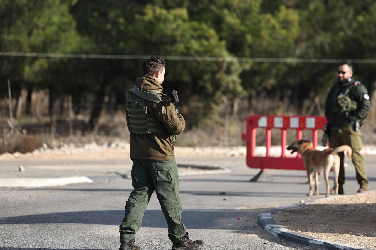 Des soldats israéliens bloquent la route menant à la frontière avec la Syrie, dans la zone du Golan annexée par Israël. [KEYSTONE - ATEF SAFADI]