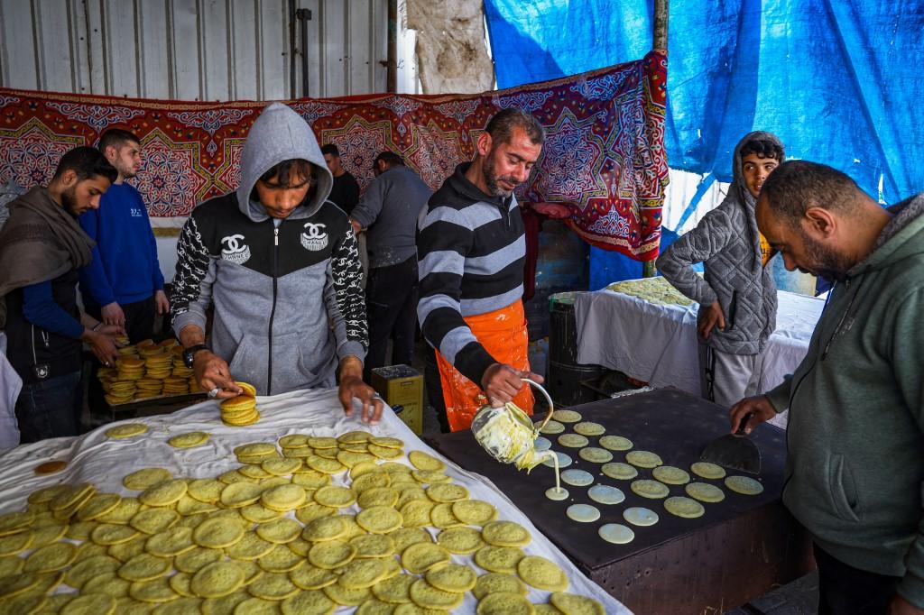 Des vendeurs préparent des Qatayef, des crêpes traditionnelles préparées pendant le mois du Ramadan, dans le sud de la bande de Gaza, le 12 mars 2024. [AFP - -]