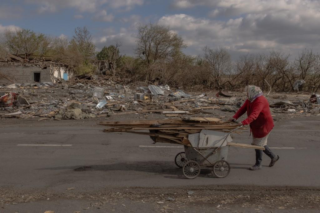 Une femme âgée ramasse du bois avant l'hiver dans une zone récemment bombardée, au sud de la ville de Pokrovsk, à l'est de l'Ukraine. [AFP - ROMAN PILIPEY]