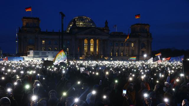 Des manifestants brandissent leurs téléphones portables pour illuminer l'esplanade du Reichstag à Berlin, lors d'un rassemblement contre l'extrême droite, le dimanche 21 janvier. [AFP - Christian Mang]