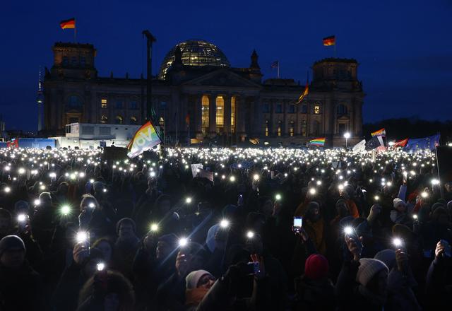 Des manifestants brandissent leurs téléphones portables pour illuminer l'esplanade du Reichstag à Berlin, lors d'un rassemblement contre l'extrême droite, le dimanche 21 janvier. [AFP - Christian Mang]