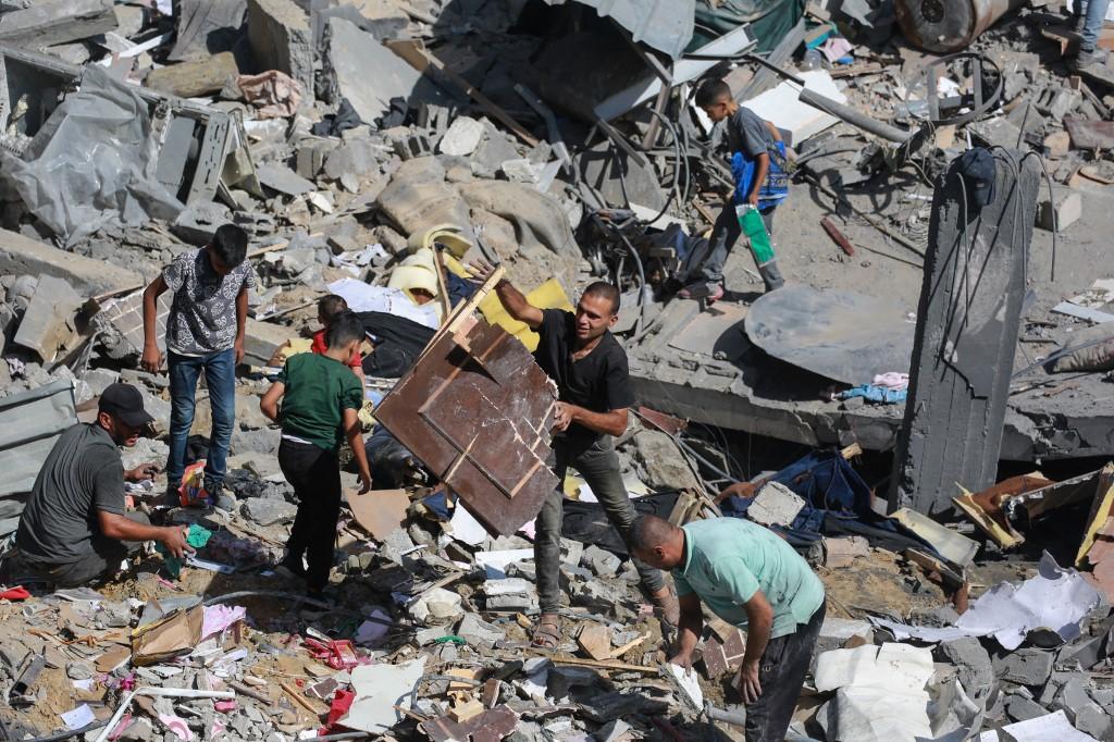 Des Gazaouis fouillent les décombres dans le camp de réfugiés d'al-Bureij, le 18 juin, après une nouvelle nuit de frappes. [AFP - BASHAR TALEB]