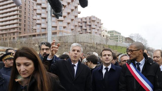 Le président français Emmanuel Macron (centre), accompagné du directeur général de la Solideo Nicolas Ferrand (gauche) et du maire de Saint-Ouen-sur-Seine Karim Bouamrane (droite), visite le village olympique de Paris 2024 à Saint-Denis, le 29 février 2024. [AFP - LUDOVIC MARIN]