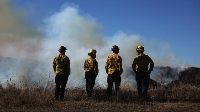 Des pompiers regardent les incendies dans le secteur de Pacific Palisades, un quartier résidentiel huppé de Los Angeles. [KEYSTONE - ALLISON DINNER]