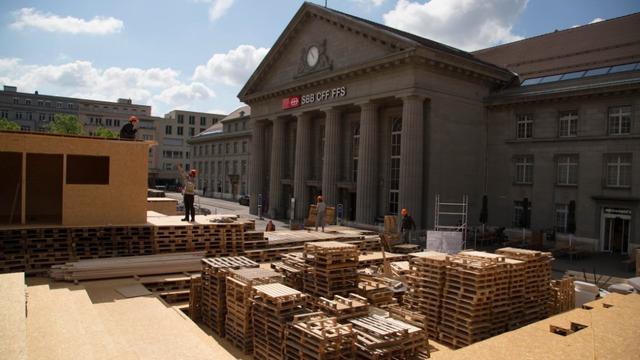 Des centaines de palettes trônent sur la place de la gare de Bienne. [Robert Walser Sculpture]