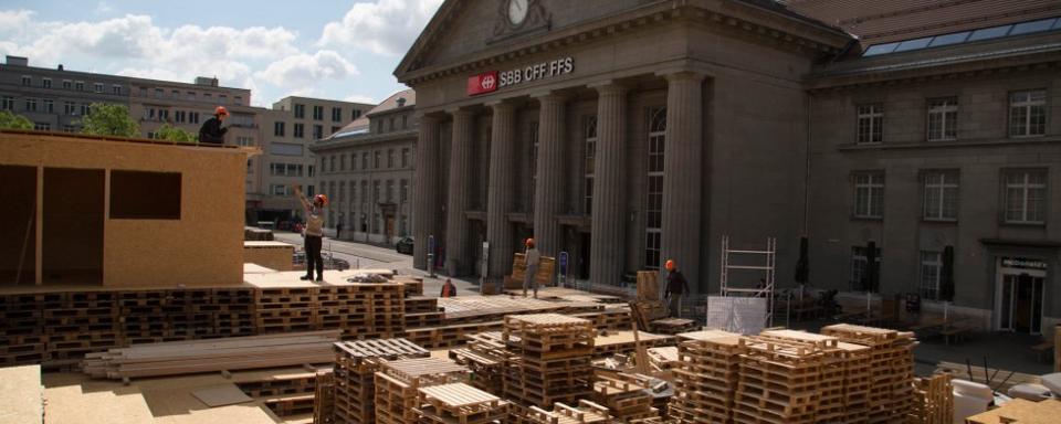 Des centaines de palettes trônent sur la place de la gare de Bienne. [Robert Walser Sculpture]