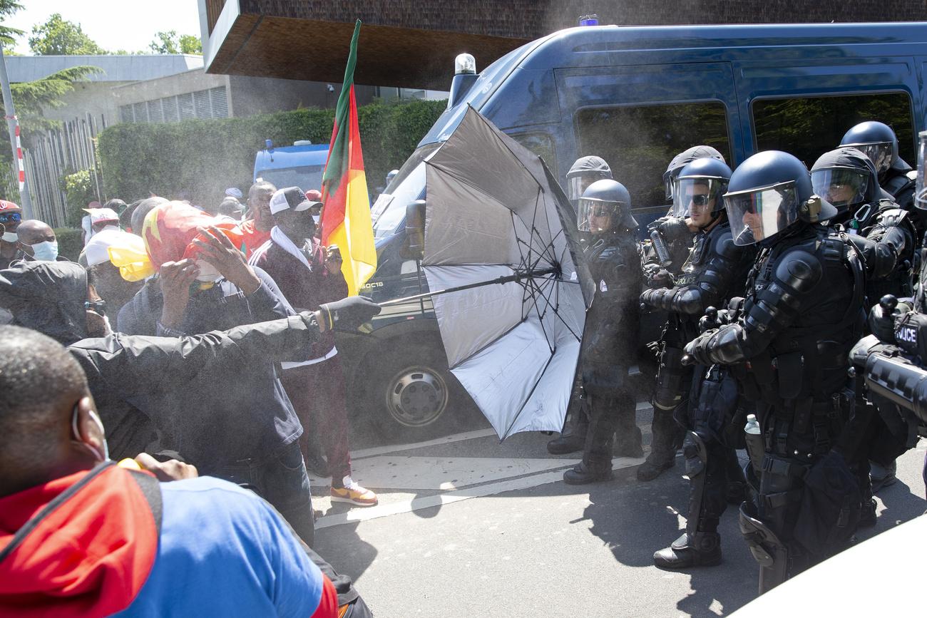 Des forces de l'ordre utilisant du gaz lacrymogène contre les manifestants. [Keystone - Salvatore Di Nolfi]