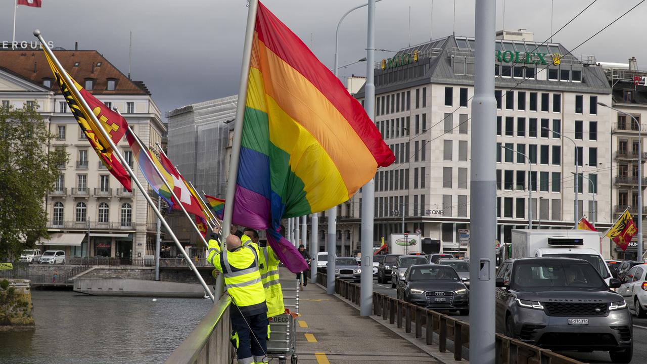 Des employés de la ville de Genève installent un drapeau pour une campagne LGBTIQ+ en 2021. [Keystone - Salvatore Di Nolfi]