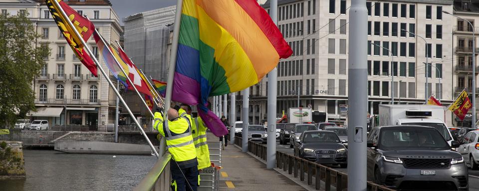 Des employés de la ville de Genève installent un drapeau pour une campagne LGBTIQ+ en 2021. [Keystone - Salvatore Di Nolfi]