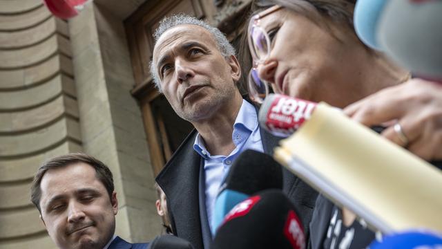 L'islamologue Tariq Ramadan, au centre, les avocats suisses Yael Hayat, à droite, et Theo Badan, à gauche, sortent et s'adressent à la presse après la lecture du verdict au palais de justice de Genève avec le procureur de Genève dans une enquête d'agression sexuelle, à Genève, en Suisse, le mercredi 24 mai 2023. [Keystone - Martial Trezzini]