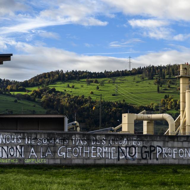 Une inscription "Non a la géothermie profonde" sur un mur à Glovelier, dans le canton du Jura. [Keystone - Jean-Christophe Bott]