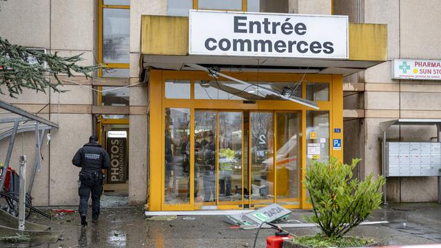 Un expert de la Police cantonale vaudoise sur les lieux de l'attaque contre le bancomat du centre commercial Migros à Montagny-près-Yverdon, le 7 décembre 2024. [KEYSTONE - JEAN-CHRISTOPHE BOTT]