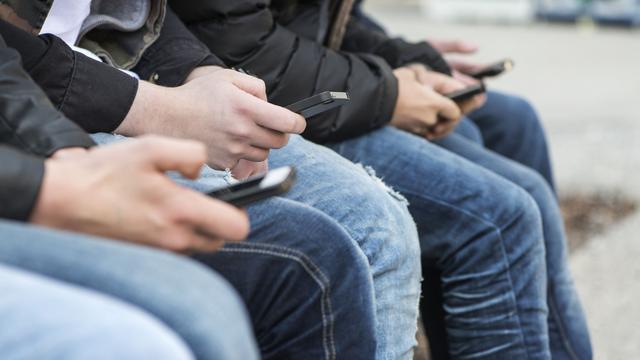 Des jeunes et leurs smartphones à Zurich. [Keystone - Christian Beutler]