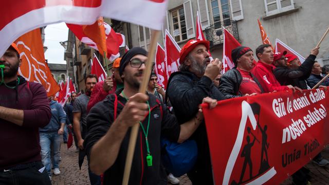 Exigeant le maintien de la retraite à 60 ans, 3000 maçons ont protesté à Bellinzone. [Keystone - Gabriele Putzu]