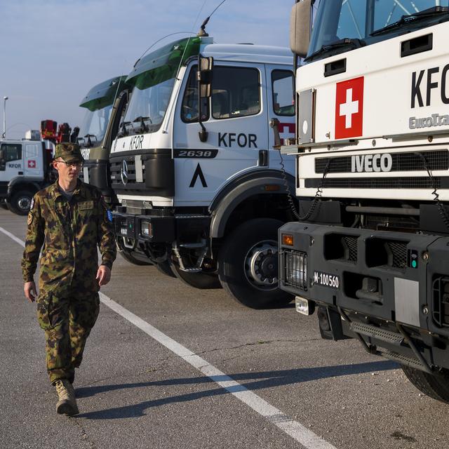 Le Capitaine Stephan Jedelhauser militaire suisse du contingent de la Swisscoy inspecte des camions. [Keystone - Jean-Christophe Bott]